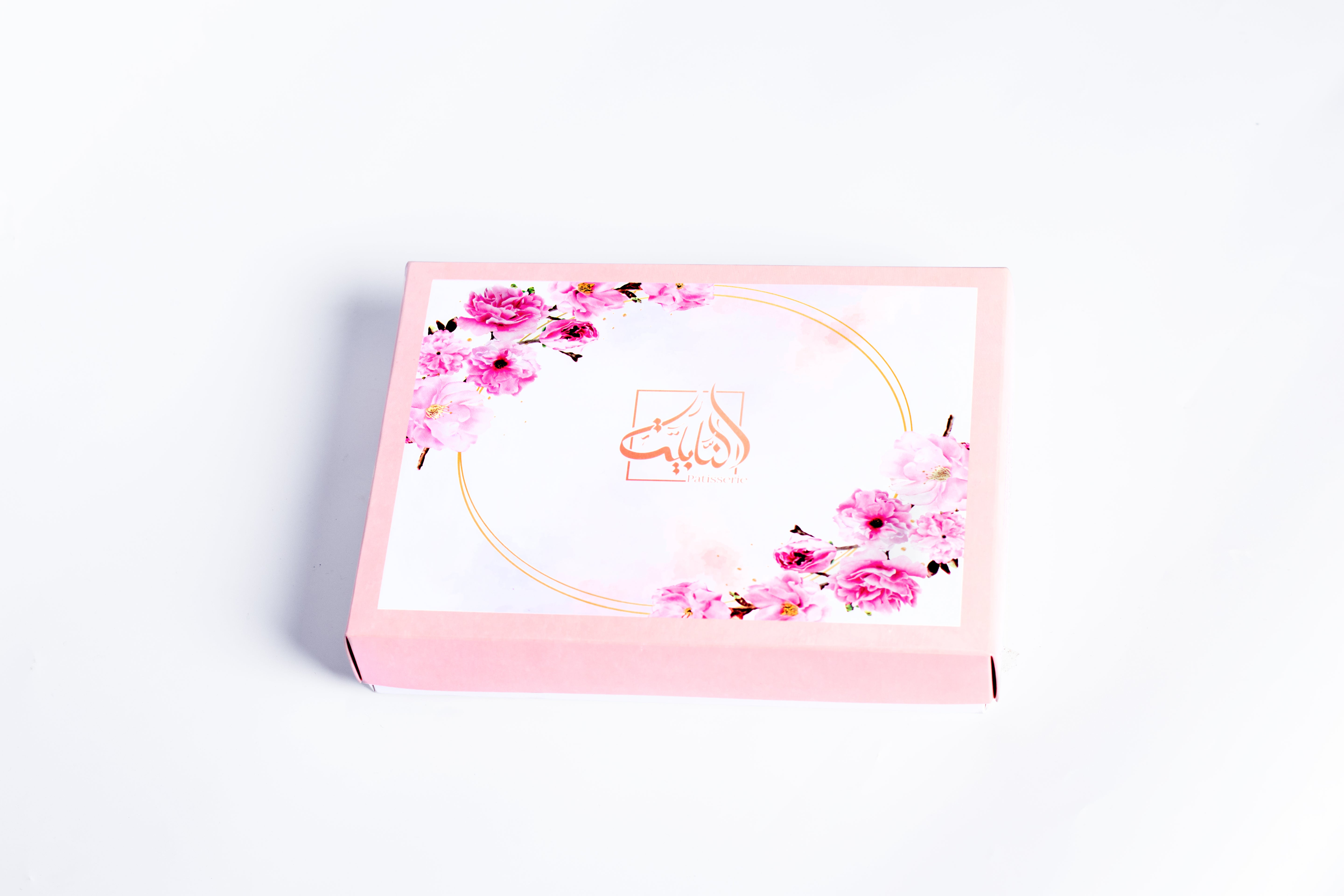 Coffret Pivoine avec 24 pâtisseries aux amandes dans une boîte blanche et rose décorée de pivoines